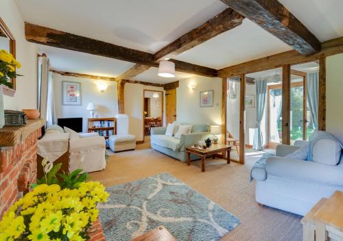 a living room with white furniture and windows at Leath Barn Cottage in Somerton