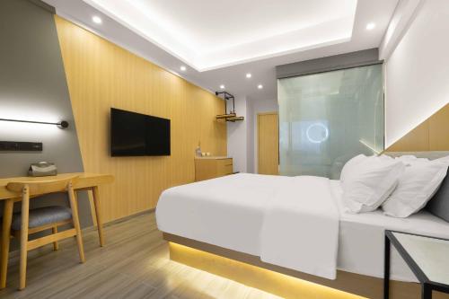 a bedroom with a bed and a desk and a television at Weiming Hotel in Chengdu