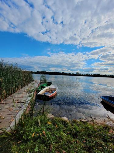 two boats are parked on the shore of a lake at Balans nad Jeziorem in Ślesin