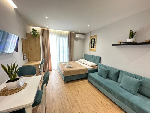 Una sala de estar con un sofá, una cama y una mesa. en TreA Accomodations - Suite Lungomare, en Vlorë