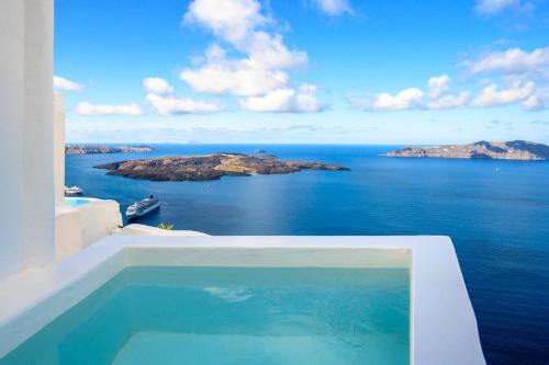 a swimming pool with a view of the ocean at Karpimo Scenery in Firostefani