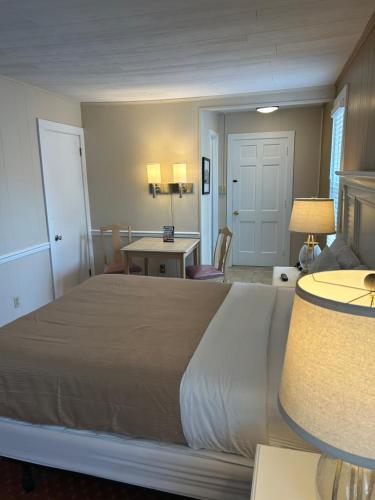 a bedroom with a large bed and a table with chairs at The Admiral Hotel/Motel in Ocean City