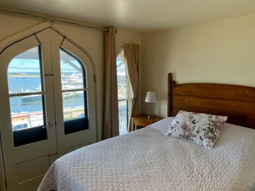 een slaapkamer met een bed en uitzicht op de oceaan bij The Attleboro House in Oak Bluffs