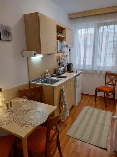 uma cozinha com um lavatório e uma mesa com cadeiras em MyRelax Apartment em Hajdúszoboszló