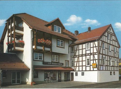 a large building with flowers on the balconies of it at Pension Selzer in Antrifttal