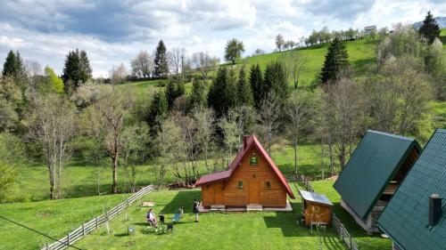 un grupo de personas de pie alrededor de una pequeña casa en Brvnara Jahorinka, en Jahorina