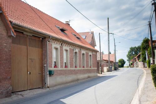 a brick building with a garage on the side of a street at Chez mumu in Frévillers