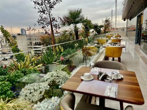 a restaurant with tables and chairs on a balcony at Reggenza Hotel Downtown Ramallah in Ramallah
