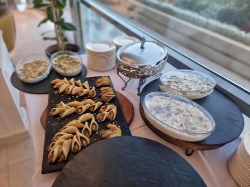 a table with plates of food and bowls of food at Reggenza Hotel Downtown Ramallah in Ramallah