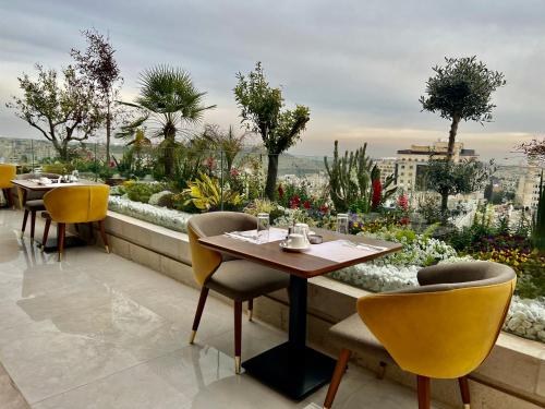 a restaurant with tables and chairs on a balcony at Reggenza Hotel Downtown Ramallah in Ramallah