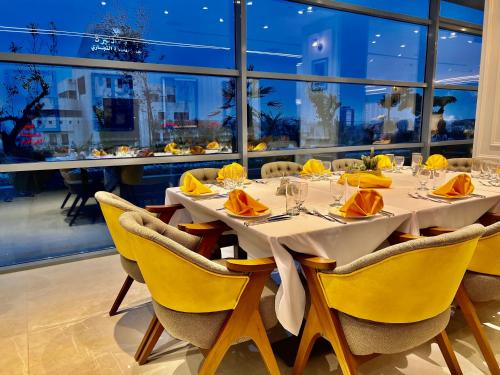 a dining room with a table with yellow chairs at Reggenza Hotel Downtown Ramallah in Ramallah