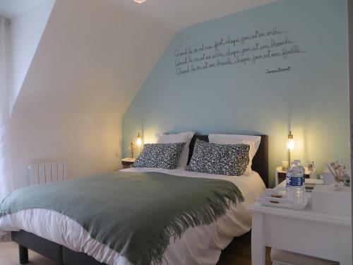 een slaapkamer met een bed met een citaat aan de muur bij Le temps d'un séjour en Bretagne Chambres d'hôtes in Nivillac