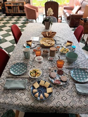 une table avec de nombreuses assiettes de nourriture dessus dans l'établissement Le temps d'un séjour en Bretagne Chambres d'hôtes, à Nivillac