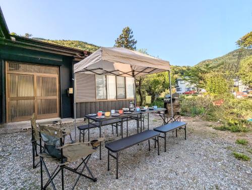 un groupe de tables et de chaises sous une tente dans l'établissement Lake Kawaguchiko, Vacation House, 3LDK BBQ OK !! 竹之家-Takenoya- Perfect for famiry and group travel !!, à Fujikawaguchiko