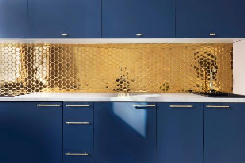 a kitchen with blue cabinets and a yellow wall at Old Town Premium by Elite Apartments in Gdańsk