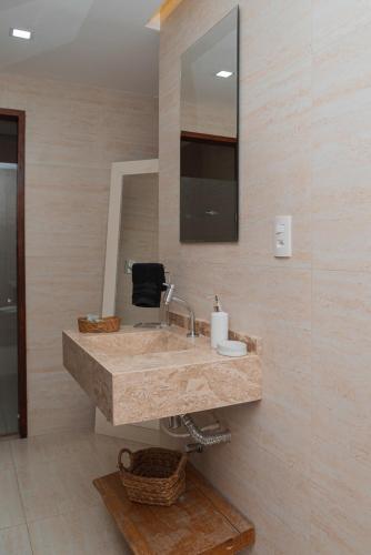 a bathroom with a sink and a mirror at Moriá Eco Lodge in Icaraí