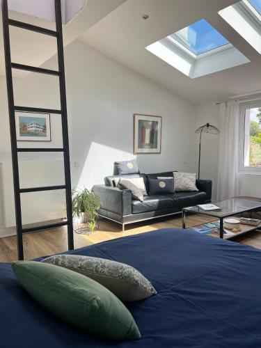 - une chambre avec une mezzanine et un canapé dans l'établissement Appartement et Studio Gîtes de L'Odet, à Clohars-Fouesnant