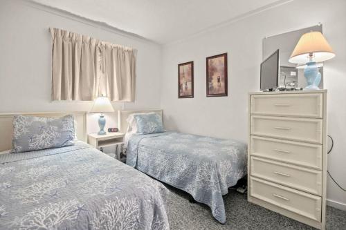 a bedroom with two beds and a dresser with a tv at Myrtle Beach Resort A532 in Myrtle Beach