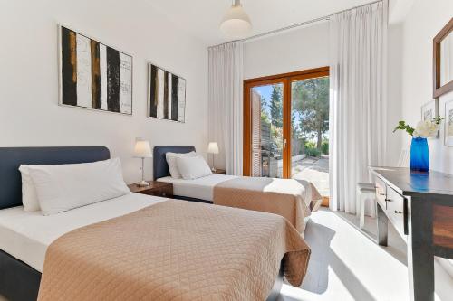 een hotelkamer met 2 bedden en een raam bij 2 bedroom Villa Proteus with private pool, Aphrodite Hills Resort in Kouklia