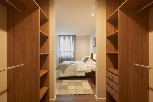 a bedroom with a bed and a closet with shelves at Caluce Apt 3C by Letoh in Chía