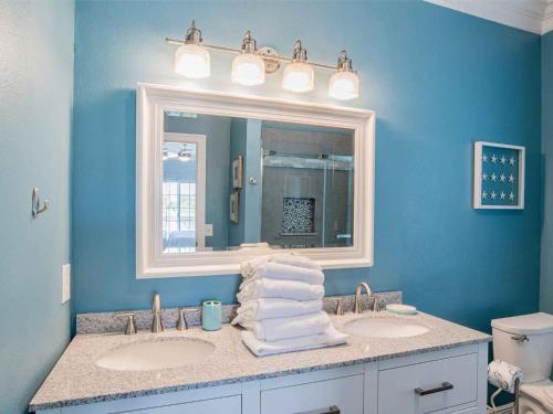 Un baño con dos lavabos y un espejo grande. en Sunglow Bungalow, en Pensacola Beach