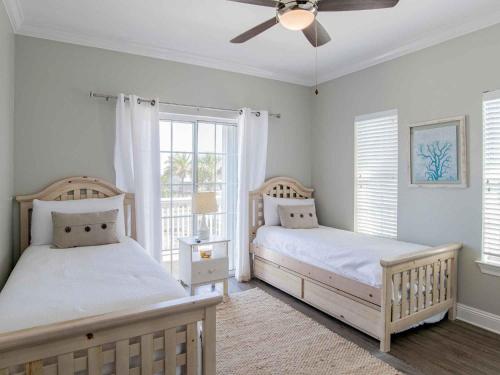 Un dormitorio con dos camas y un ventilador de techo. en Sunglow Bungalow, en Pensacola Beach