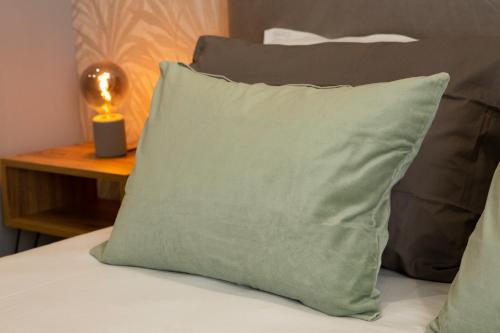- un oreiller vert assis au-dessus du lit dans l'établissement Capodichino airport house, à Naples