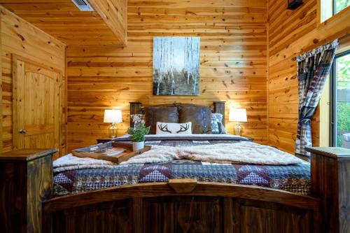 a bedroom with a bed in a log cabin at Hickory Bear - Cabin surrounded by pines, Sleeps 10, Hot Tub, Fire Pit, Arcade, Foosball Table & Deck Slide in Broken Bow