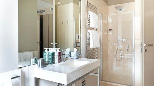 uma casa de banho branca com um lavatório e um chuveiro em Allegroitalia San Pietro All'Orto 6 em Milão