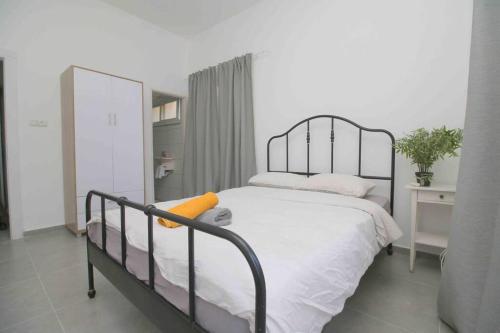 um quarto com uma cama com uma estrutura de metal em 4 Rooms steps from the beach em Tel Aviv