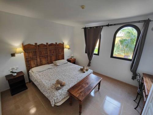 a bedroom with a bed and a table and a window at Apartment Cumbre Vieja Fuerteventura in Corralejo