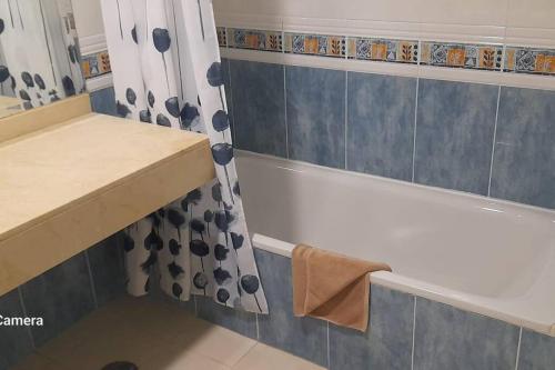 a bathroom with a tub and a shower curtain at Apartment Cumbre Vieja Fuerteventura in Corralejo