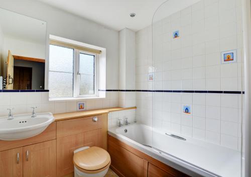 a bathroom with a tub and a sink and a toilet at 17 The Green in East Rudham
