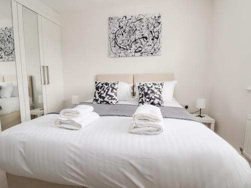 Un dormitorio con una cama blanca con toallas. en 122 The Old Meadow, en Shrewsbury