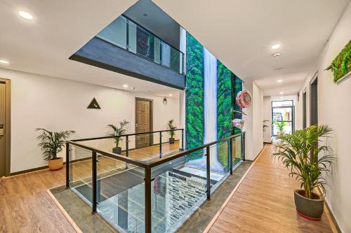 a glass staircase in a house with plants at Townhouse OAK Hillside Aqua in Khandagiri