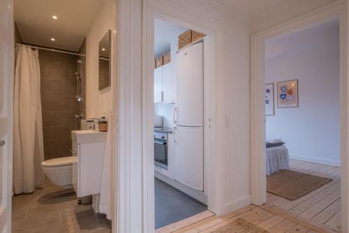 a kitchen with a white refrigerator and a toilet at Newly renovated 1-Bed Apartment in Aalborg in Aalborg