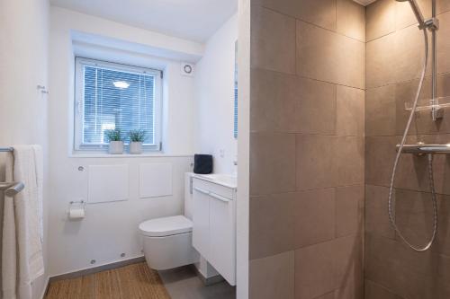 a white bathroom with a toilet and a shower at Newly renovated 1-Bed Apartment in Aalborg in Aalborg