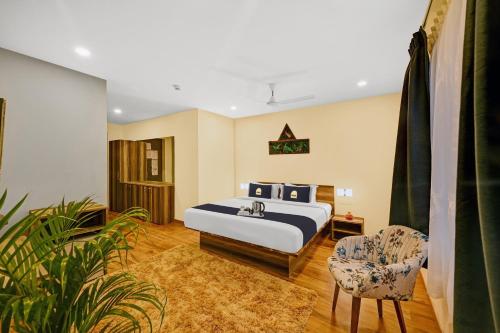um quarto com uma cama king-size e uma cadeira em Townhouse OAK Hillside Aqua em Khandagiri