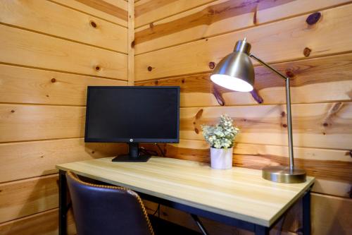 a desk with a computer monitor and a lamp on it at Hickory Bear - Cabin surrounded by pines, Sleeps 10, Hot Tub, Fire Pit, Arcade, Foosball Table & Deck Slide in Broken Bow