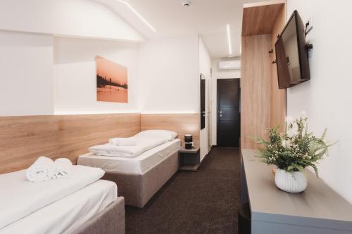 Pokój szpitalny z dwoma łóżkami i telewizorem w obiekcie Bells Osijek w mieście Osijek