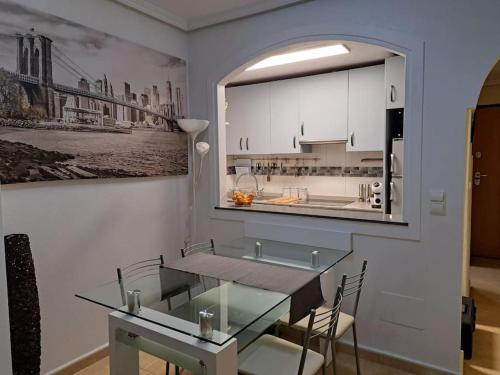a kitchen with a glass table in a room at Apartament Julia de LUX in Torrevieja