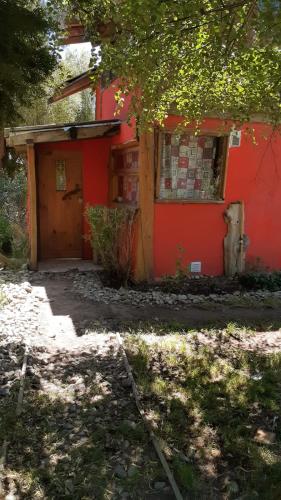 a red house with a door and a window at Cabaña km 12,7 in San Carlos de Bariloche