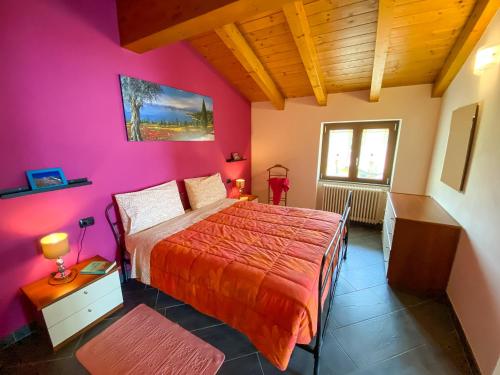 una camera con letto e parete rosa di Giardino di Maria - Papavero Panoramawohnung (DG) a Vercana
