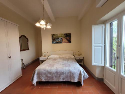 1 dormitorio con 1 cama, 2 mesas y una ventana en Casa Volpini, en Panzano