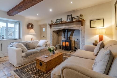 a living room with two couches and a fireplace at Peach Cottage in Poulton