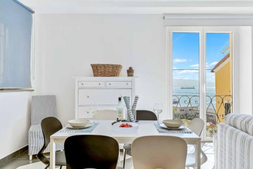 een witte eetkamer met een witte tafel en stoelen bij Equilibrium, Terre Marine, Marola in La Spezia