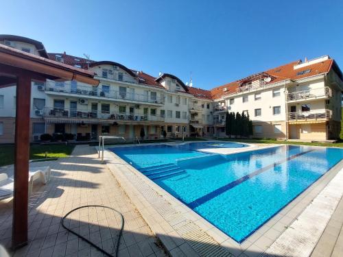 uma grande piscina em frente a alguns edifícios em MyRelax Apartment em Hajdúszoboszló