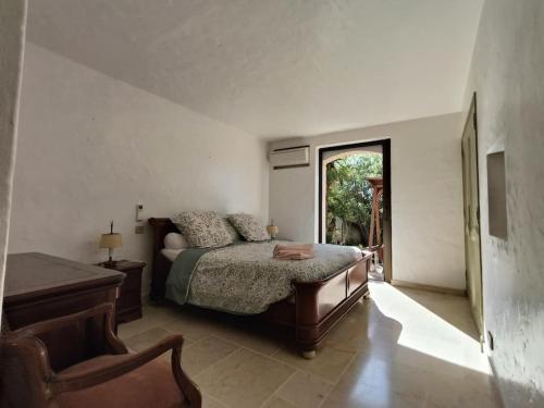 une chambre avec un lit, une chaise et une fenêtre dans l'établissement Villa avec piscine 8 personnes, à Fréjus