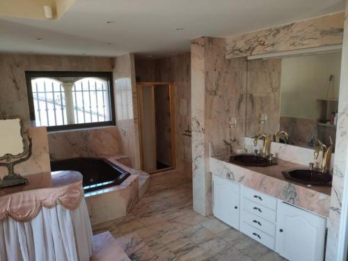 La grande salle de bains est pourvue de 2 lavabos et d'une baignoire. dans l'établissement Villa avec piscine 8 personnes, à Fréjus