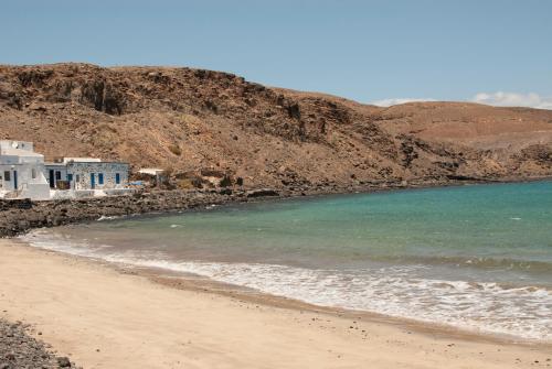 a beach with a house and the ocean at Casa Belén in Pozo Negro